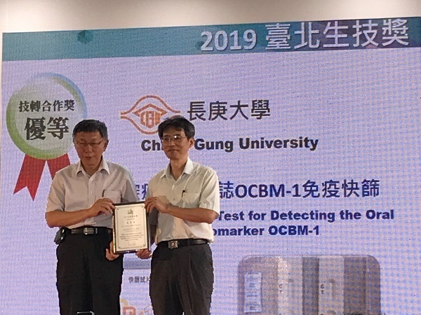 余兆松教授(圖右)代表分醫中心與世延生醫團隊接受柯文哲市長(圖左)頒獎